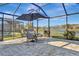 Screened patio with table, chairs, and umbrella overlooking a lake at 3533 Lakewood Blvd, North Port, FL 34287