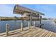 Wooden dock with a covered boat lift at 407 Dunn Ne Dr, Port Charlotte, FL 33952