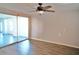 Bedroom with ceiling fan, wood-look floors, and sliding doors to sunroom at 4200 Kilpatrick St, Port Charlotte, FL 33948