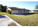 Side view of the house with a concrete driveway and a green lawn at 4200 Kilpatrick St, Port Charlotte, FL 33948