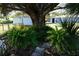 Landscaped backyard with stone path, tropical plants and large tree at 422 Omen St, Punta Gorda, FL 33982