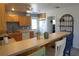 Kitchen with wood cabinets, an island, and view into laundry room at 422 Omen St, Punta Gorda, FL 33982