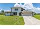 Two-story house with a beige exterior, two-car garage, and lush green lawn at 4630 Fallon Cir, Port Charlotte, FL 33948