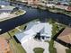 Aerial view of waterfront home showcasing metal roof and paver driveway at 490 Sorrento Ct, Punta Gorda, FL 33950