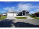 Modern home exterior with three-car garage and paver driveway at 490 Sorrento Ct, Punta Gorda, FL 33950