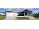 Modern home exterior with three-car garage and paver driveway at 490 Sorrento Ct, Punta Gorda, FL 33950