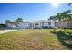 White single-story home with a tile roof, palm trees, and a landscaped lawn at 525 Port Bendres Dr, Punta Gorda, FL 33950