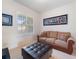 Cozy living room with a brown sofa and ottoman at 700 Gardens Edge Dr # 722, Venice, FL 34285