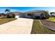 Exterior view of a single-story home with a driveway and landscaped yard at 900 Genoa Ct, Punta Gorda, FL 33950