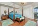 Spacious bedroom with wood floors, a four-poster bed, and access to a patio at 1014 Francesca Ct, Punta Gorda, FL 33950