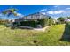 Backyard view of a house with a screened patio and well-manicured lawn at 1014 Francesca Ct, Punta Gorda, FL 33950