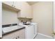 Bright laundry room with washer, dryer, cabinets, and utility sink at 1014 Francesca Ct, Punta Gorda, FL 33950