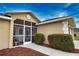 Screened porch entry to tan house with landscaping at 110 Albatross Rd, Rotonda West, FL 33947