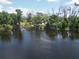 Aerial view shows the property with a tranquil pond and surrounding greenery at 1136 Davis Ln, Englewood, FL 34224