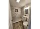 Updated bathroom with marble-look tile and modern vanity at 1136 Davis Ln, Englewood, FL 34224