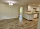 Open dining area with wood-look tile floors and view to kitchen at 1136 Davis Ln, Englewood, FL 34224