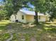 Rear exterior view of the house, showcasing the metal roof and light yellow siding at 1136 Davis Ln, Englewood, FL 34224
