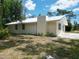 House exterior showcases a metal roof and freshly painted light yellow siding at 1136 Davis Ln, Englewood, FL 34224