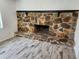 Stone fireplace with wood-look tile flooring at 1136 Davis Ln, Englewood, FL 34224