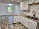 Kitchen with white cabinets, granite counters, and stainless steel appliances at 1136 Davis Ln, Englewood, FL 34224