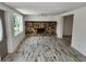 Bright living room featuring a stone fireplace and wood-look tile floors at 1136 Davis Ln, Englewood, FL 34224