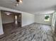 Open living area with wood-look tile floors, leading to the kitchen and dining area at 1136 Davis Ln, Englewood, FL 34224