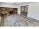 Bright living room featuring a stone fireplace and wood-look tile floors at 1136 Davis Ln, Englewood, FL 34224