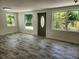 Bright living room with wood-look tile floors and ample natural light at 1136 Davis Ln, Englewood, FL 34224