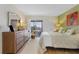 Bright bedroom with water view, dresser, and comfortable bed at 1345 Mediterranean Dr # A204, Punta Gorda, FL 33950
