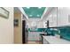 Modern kitchen with white cabinets and teal backsplash at 1345 Mediterranean Dr # A204, Punta Gorda, FL 33950