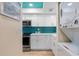 Modern kitchen with white cabinets and teal backsplash at 1345 Mediterranean Dr # A204, Punta Gorda, FL 33950