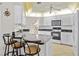 Bright kitchen with white cabinetry, granite countertops, and an island with bar stool seating at 1346 Osprey Dr, Punta Gorda, FL 33950