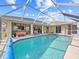 Backyard pool with a screened enclosure, seating area, and well-maintained landscaping at 1346 Osprey Dr, Punta Gorda, FL 33950