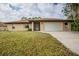 Single-story house with attached garage and well-maintained lawn at 1477 Fringe St, Port Charlotte, FL 33952