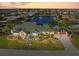 Panoramic aerial view of a waterfront property with lush landscaping, a private dock, and stunning sunset views at 1701 Casey Key Dr, Punta Gorda, FL 33950