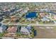 Aerial view of a home with a green roof, lush landscaping, a view of the adjacent homes, and a canal at 1701 Casey Key Dr, Punta Gorda, FL 33950