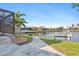A scenic backyard with a lush lawn, a boat dock, and waterfront views for outdoor enjoyment at 1701 Casey Key Dr, Punta Gorda, FL 33950