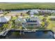 Aerial view of a home with a green roof, lush landscaping, a screened-in patio and a dock on the canal at 1701 Casey Key Dr, Punta Gorda, FL 33950