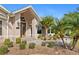 Attractive home featuring a decorative glass door and a beautifully landscaped front yard with tropical plants and a stone pathway at 1701 Casey Key Dr, Punta Gorda, FL 33950