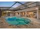 A sparkling in-ground pool featuring a built-in fountain and surrounded by a screened enclosure and stone patio at 1701 Casey Key Dr, Punta Gorda, FL 33950