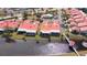 Aerial view of community, featuring a canal, pool, and numerous villas with red roofs at 1890 Deborah Dr # 14, Punta Gorda, FL 33950