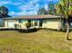 Newly renovated home with a landscaped lawn at 18938 Ayrshire Cir, Port Charlotte, FL 33948