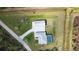 Aerial perspective of a home with a pool and separate garage on a large, green lot, providing a sense of privacy at 2154 Azure Rd, North Port, FL 34286