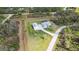 Aerial view showcasing a modern home with a pool, detached garage, and a spacious, verdant lawn at 2154 Azure Rd, North Port, FL 34286