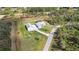 A serene aerial view shows a home with a pool and a detached garage on a sprawling green lawn at 2154 Azure Rd, North Port, FL 34286