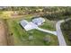 An aerial view of a modern home with a detached garage, beautiful lawn, and screened-in pool in a lush setting at 2154 Azure Rd, North Port, FL 34286