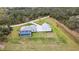 Expansive aerial view of a modern home with a screened pool, detached garage, and a long driveway through a lush landscape at 2154 Azure Rd, North Port, FL 34286
