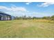 Expansive green backyard featuring a pool enclosure and natural landscape at 2154 Azure Rd, North Port, FL 34286