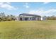 Expansive backyard featuring a screened-in lanai, lush lawn, and an additional building on the property at 2154 Azure Rd, North Port, FL 34286