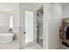 Bright bathroom features marble floors and walls, soaking tub, glass-enclosed shower, and walk-in closet with custom shelving at 2154 Azure Rd, North Port, FL 34286